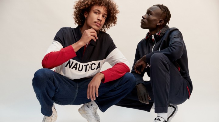 Two men of colour crouching down wearing blue and white activewear.