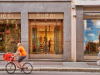 A Gucci store front with a cyclist at the front.