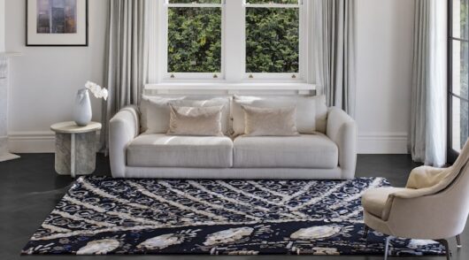 ] campaign image of styled living room featuring steven khalil and designer rugs collaboration detailed blue and beige rug and neutral furniture