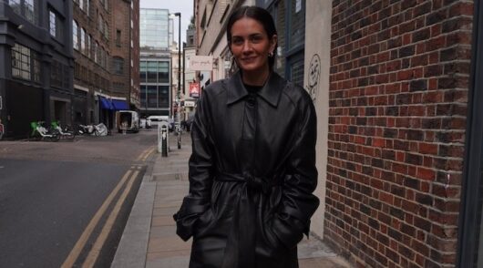 Street style Mid shot image of Beare Park director and founder Gabriella Pereira 2024 in black leather trench coat in alleyway