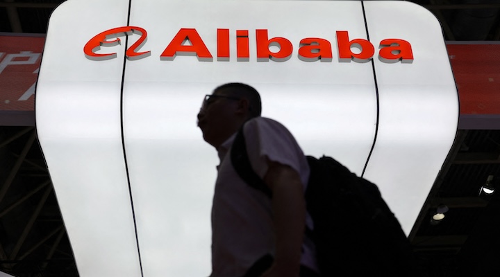 A man walks past the Alibaba logo displayed at its booth during the China International Supply Chain Expo in Beijing, China July 16, 2025.