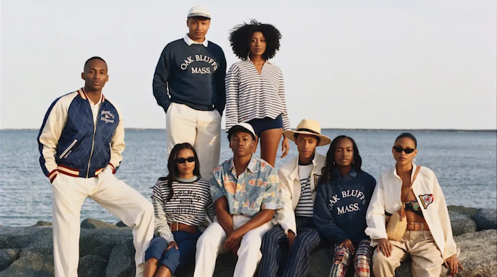 A shot Ralph Lauren’s Oak Bluffs collection featuring several models wearing coordinating blue-and-white ensembles, standing in front of an ocean.