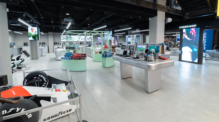 An interior shot of the Tm:rw store with various technology products and a racecar spread throughout the space.