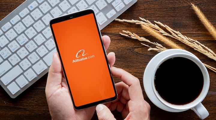 Hands hoding mobile with Alibaba screen