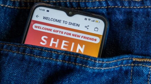 Smartphone in the back pocket of a jean, with Shein app Store on the screen