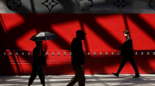 People walk in front of the new Louis Vuitton store in Shanghai