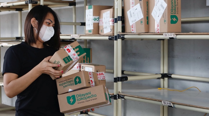 An employee packs goods at Goto's e-commerce unit Tokopedia's warehouse in Jakarta, Indonesia