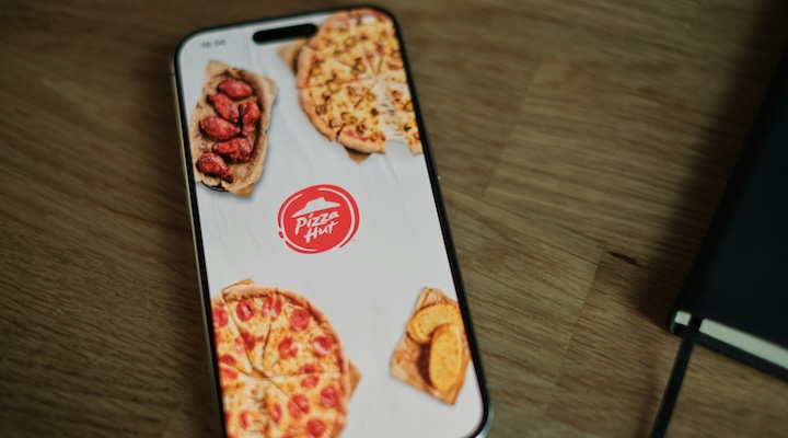 A Pizza Hut phone case sitting on top of a wooden table