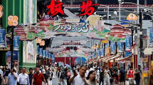 People walk along a shopping street in Shanghai, China